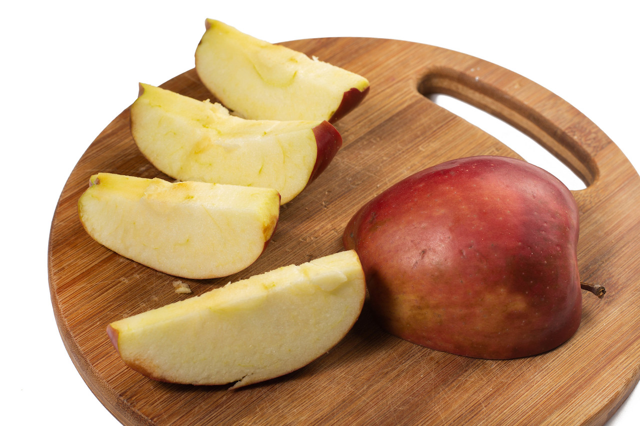 Sliced red apples on a wooden board